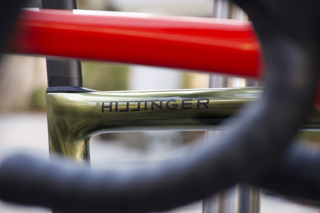 Nahaufnahme eines Fahrradrahmens der Marke Hillinger mit olivgrüner Lackierung, roten Akzenten und schwarzem Lenker.