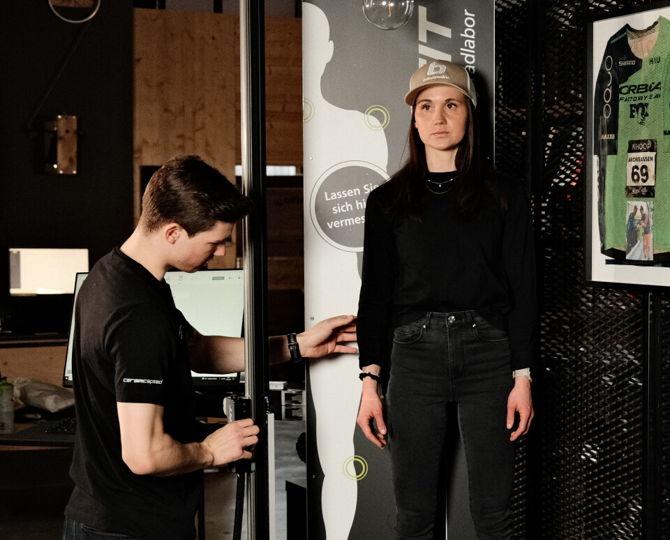 Intersport-Mitarbeiterin vermisst Kundin für Bikefitting in einem Sportgeschäft.