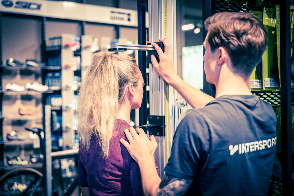 Intersport-Mitarbeiterin vermisst Kundin für Bikefitting in einem Sportgeschäft.