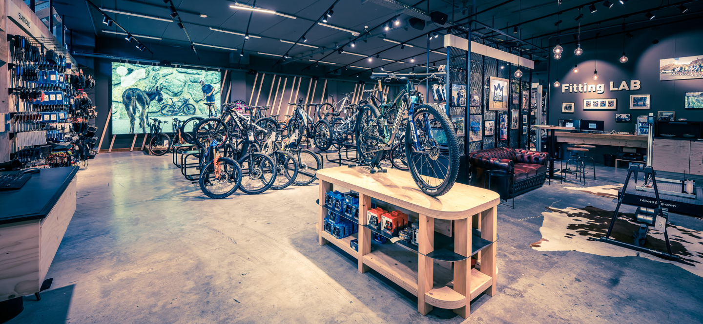 Fahrradladen-Interieur mit ausgestellten Mountainbikes, Verkaufsfläche mit Fahrradausrüstung.